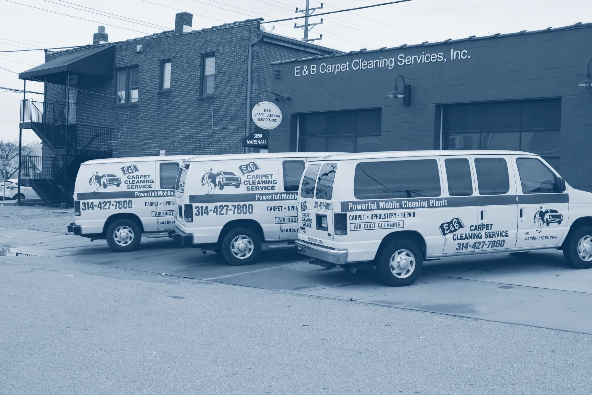 Three E&B vans parked outside the shop in St. Louis
