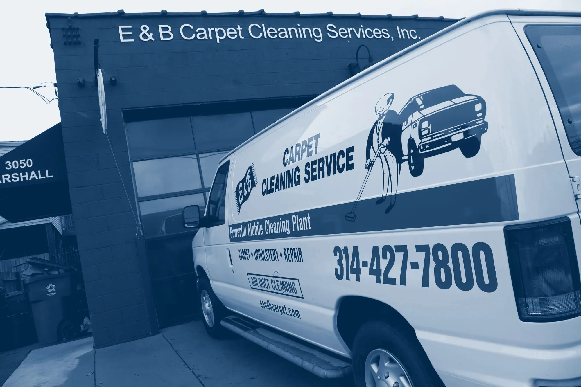 An E&B van with the tuxedo mascot and 314-427-7800 on the side, parked at the shop at 3050 Marshall Avenue