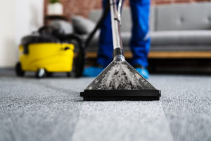 A cleaning wand leaving a clean stripe across gray carpet