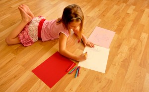 Little girl coloring on hardwood floor, how to clean a hardwood floor