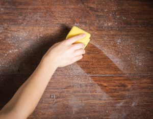 picture of person removing dust from a table